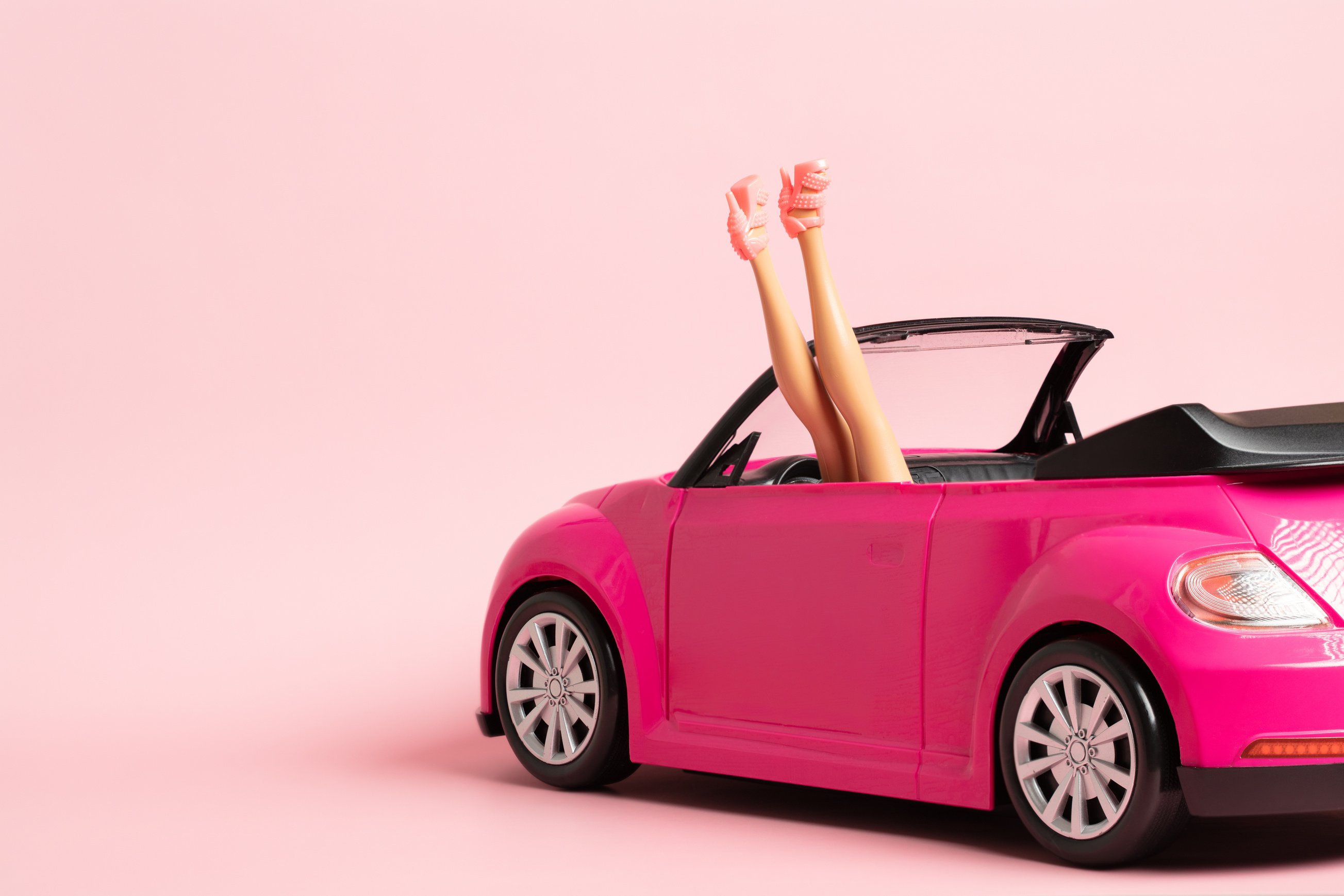 Doll Legs Sticking Out of a Pink Car. Fashion, Summer Trip, Vacation Concept.